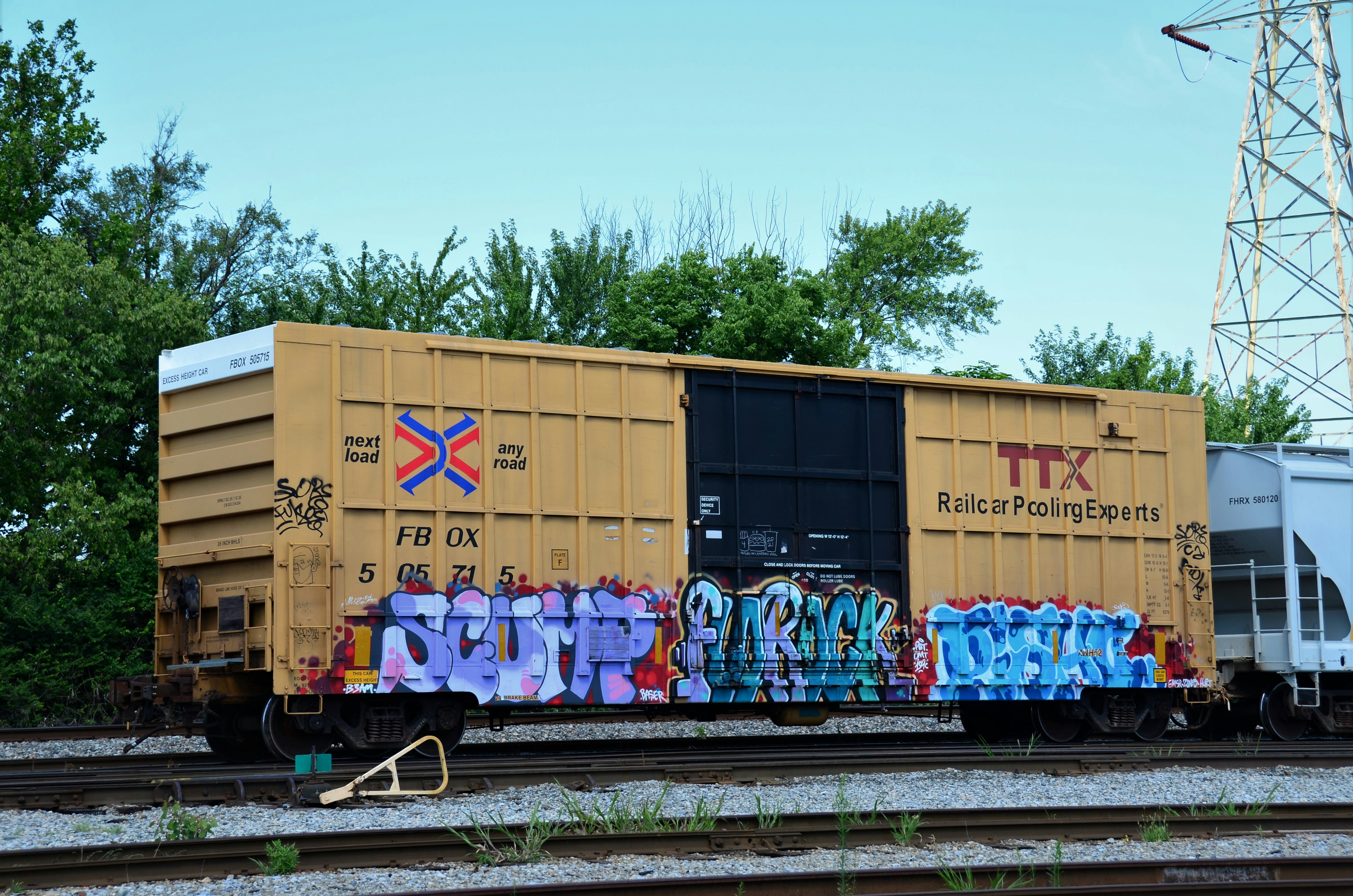 Yellow boxcar with colored graffiti